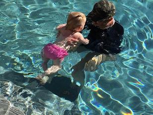 Toddler swimming with instructor at a Palm Beach County pool