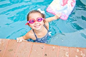 Child with goggles smiling during swim lesson in North Palm Beach